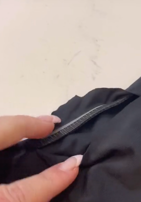 Close-up of black swimsuit interior showcasing inner grip strip along the seam on a white countertop