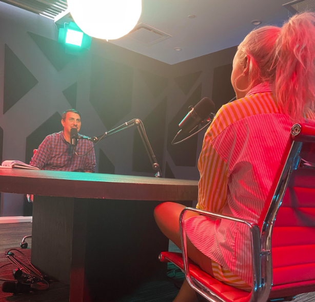 Onewith founder interviewed on CT Startup Podcast in studio, two people at table with microphones and colored lighting
