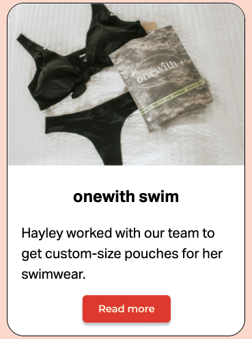 Black two-piece bikini laid next to a reusable onewith-branded eco-friendly pouch on a white quilted surface