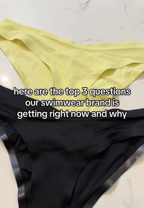 Flat lay of black and pale yellow bikini bottoms showing smooth fabric and V-shaped front on a white marble background