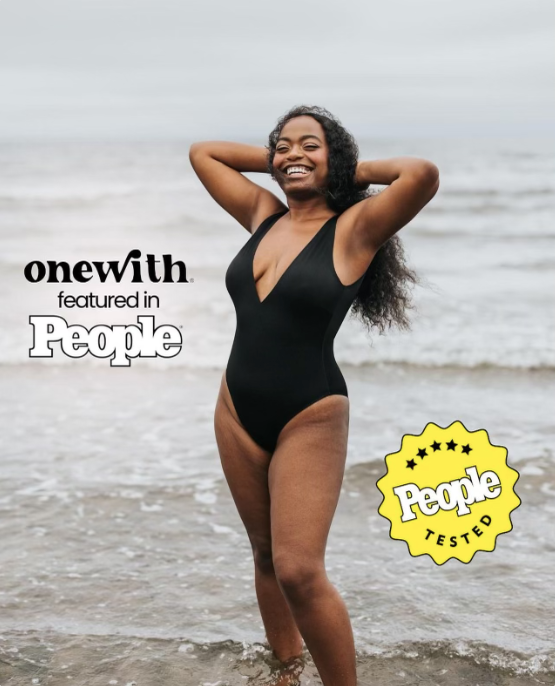 Smiling woman in black one-piece standing in shallow ocean waves; overlay text 'onewith featured in People' and yellow badge.