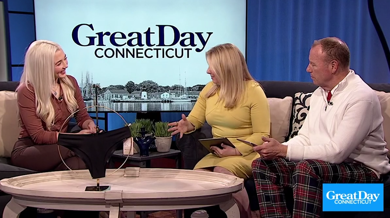 Two hosts and Hayley Segar seated on GreatDay CONNECTICUT set with a black product on the coffee table between them