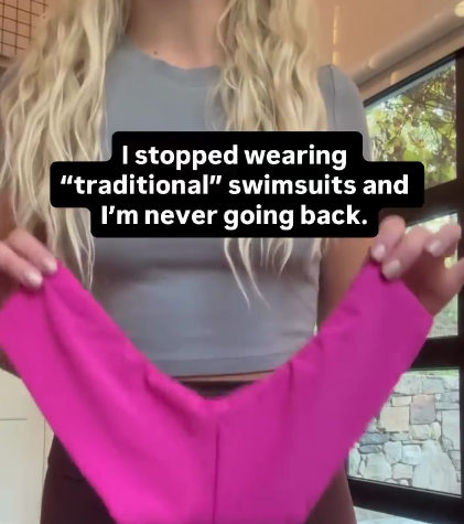 Person holding magenta one-piece swimsuit; overlaid text: I stopped wearing 'traditional' swimsuits and I'm never going back.