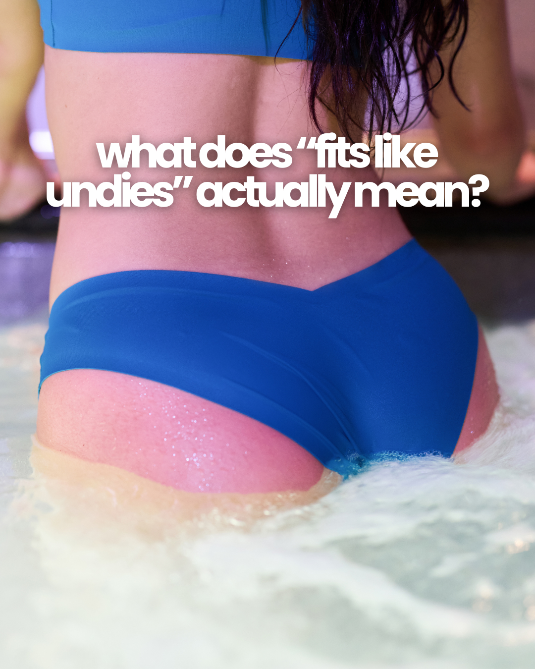 Rear view of person wading in water wearing blue raw-cut bikini bottoms with headline “what does “fits like undies” actually mean?”