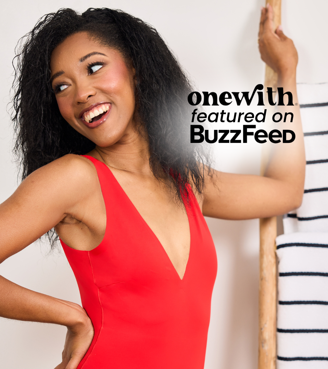 Woman in red Bellows plunge high-cut one-piece smiling beside onewith featured on BuzzFeed overlay