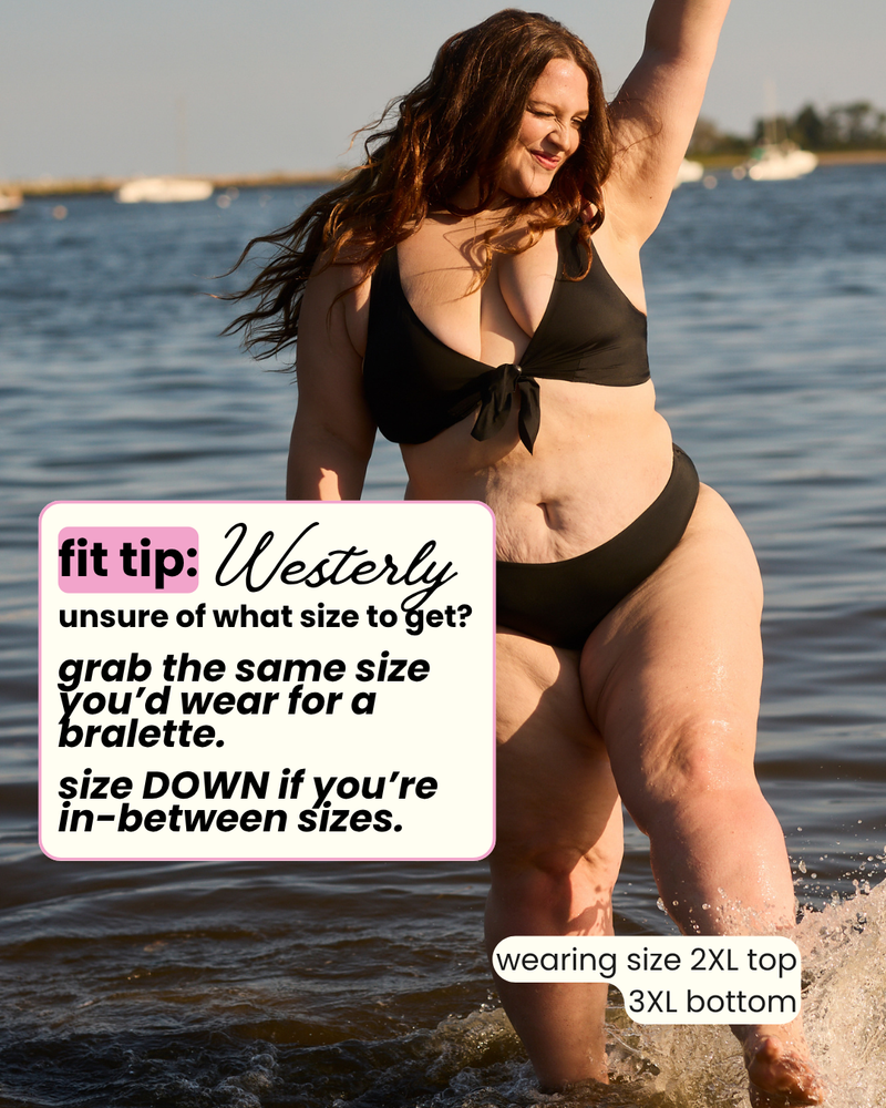 Woman in a black bikini standing in water with text overlay about swimwear size guidance.