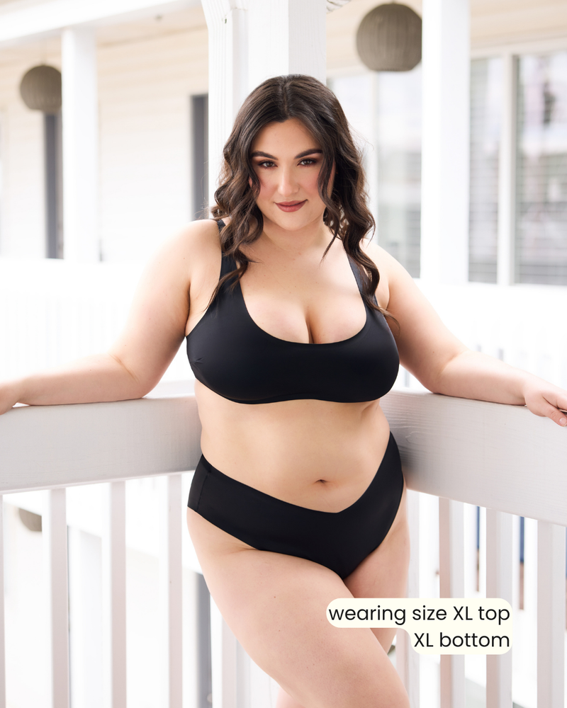 Woman wearing a black bikini set with text indicating size information 