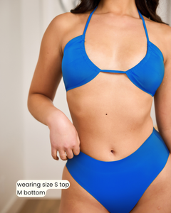 Woman wearing a blue bikini with text indicating size information.