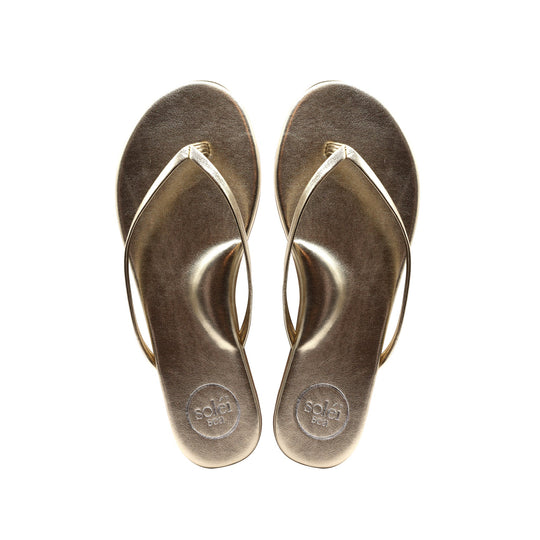 Top-view of a pair of brown flip-flops with circular logos on the heels