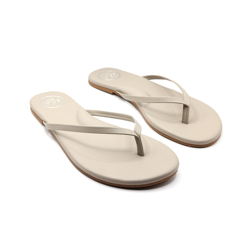 Beige foam flip-flop sandals, pair with thong straps photographed at a slight angle