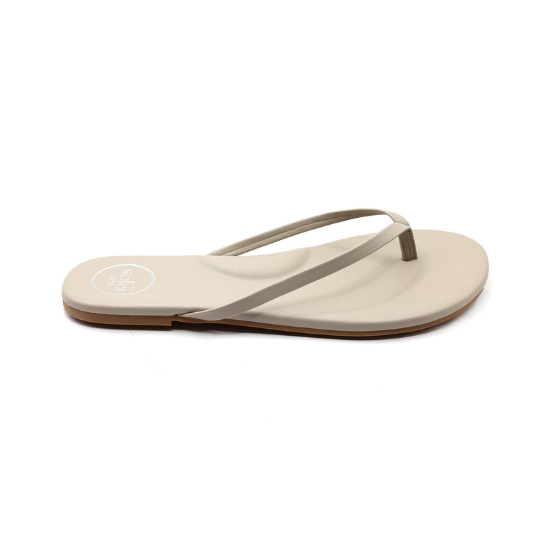 Beige flat thong sandal (flip-flop) with thin straps, side view.