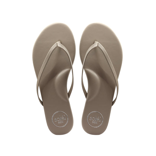 Top view of tan flip-flops with white thong straps and circular sole patterns