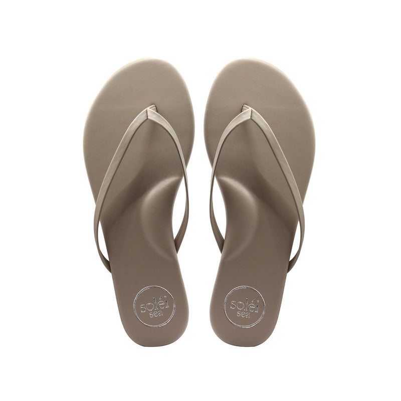 Top view of tan flip-flops with white thong straps and circular sole patterns