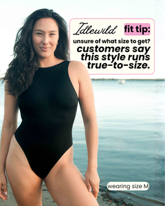 Woman wearing a black swimsuit on a beach with text overlay about size guidance.