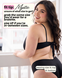 Woman wearing a black bikini with text on sizing advice.
