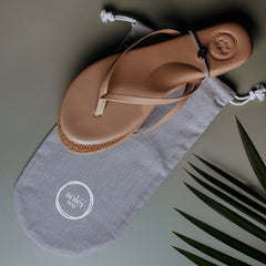 Tan leather thong sandal with embossed circular logo on the heel and white printed logo on the footbed.