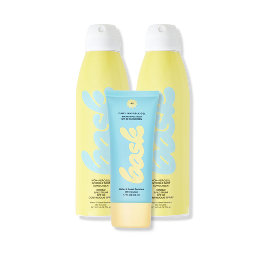 Two yellow spray sunscreens flanking a blue tube labeled bask