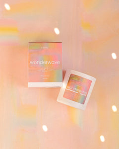 Two overlapping square photo frames on a soft peach background with pastel light flares and floating sparkles.